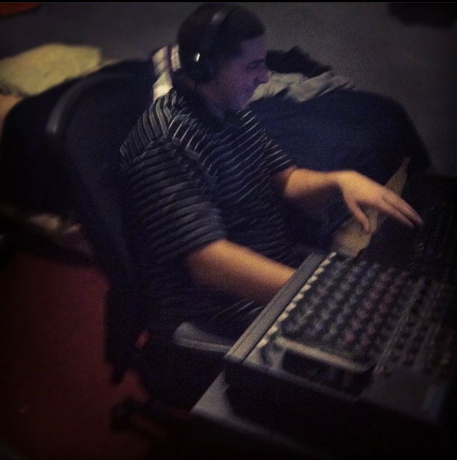 Working the faders on a mixing board with headphones on
